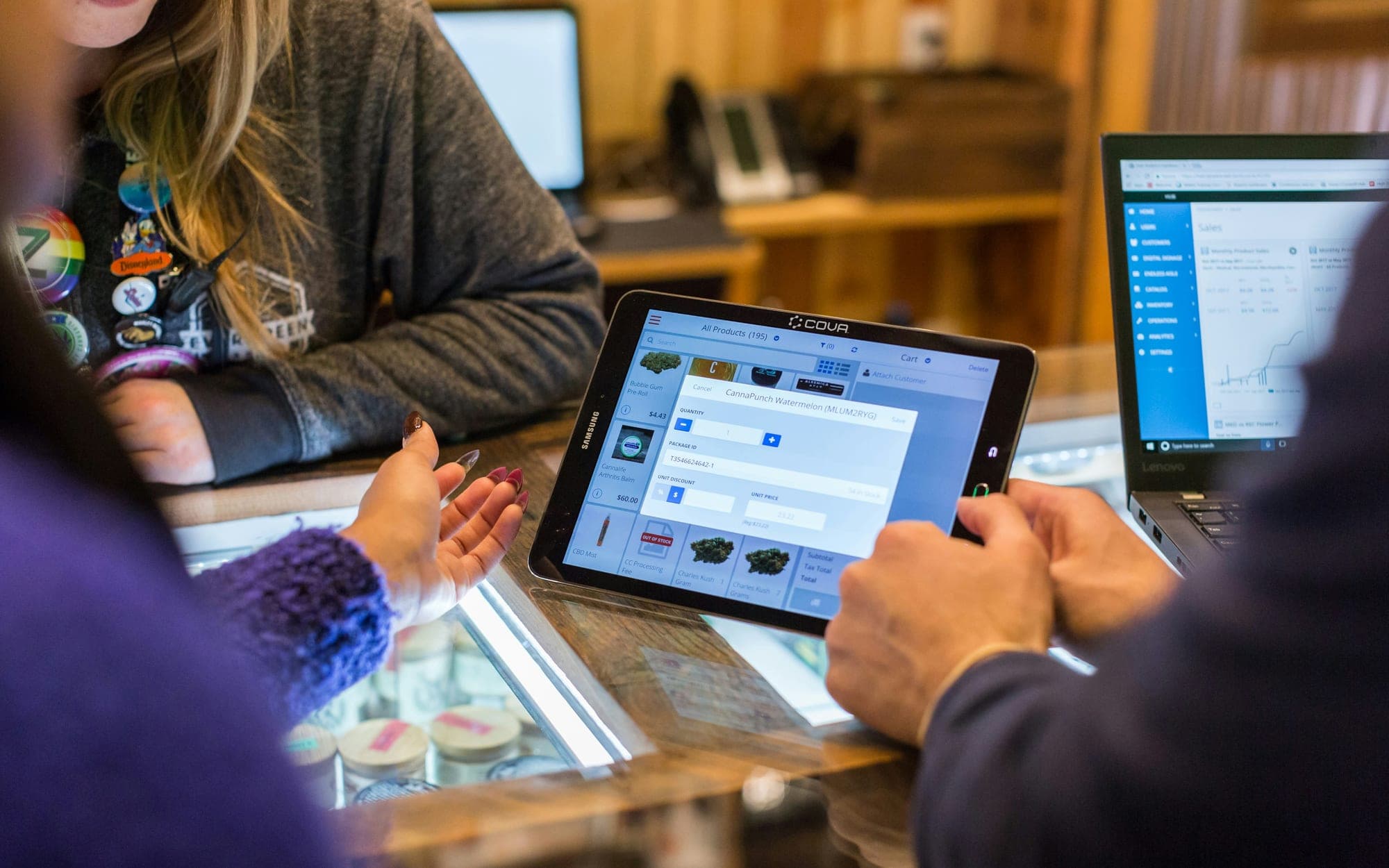 A member of staff serving a customer using a tablet at a counter