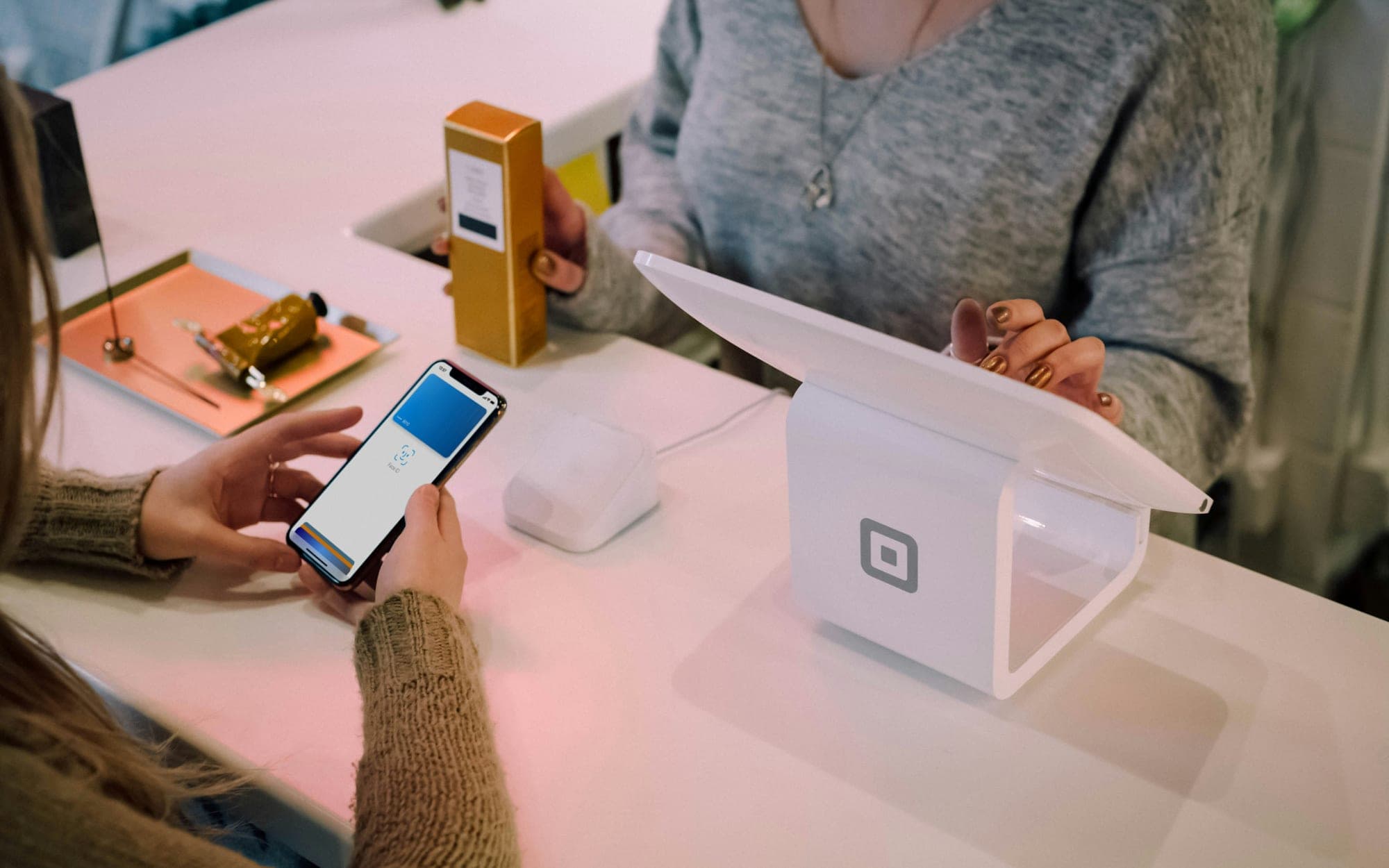 A customer paying by phone at a card terminal