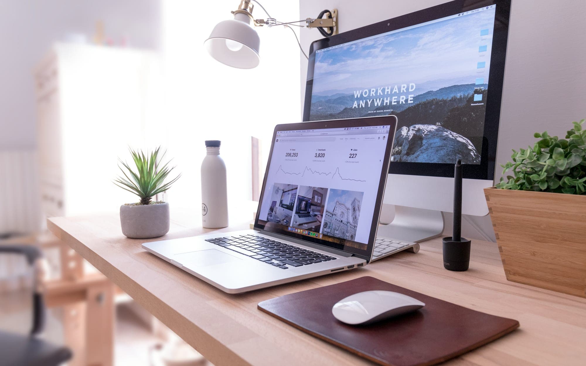 A monitor and laptop on a desk showing a website design